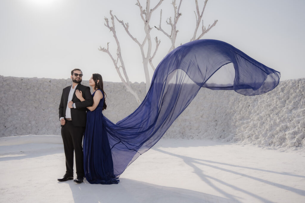 A collage of top pre-wedding shoot locations in Jaipur: a traditional Rajasthani stone archway, the lakeside at Jal Mahal, a cinematic night set with chandeliers, and the white marble landscapes of Kishangarh.